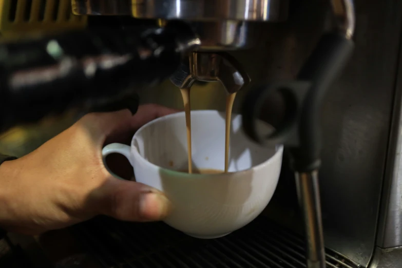 a person in gloves is mixing liquid from a cup