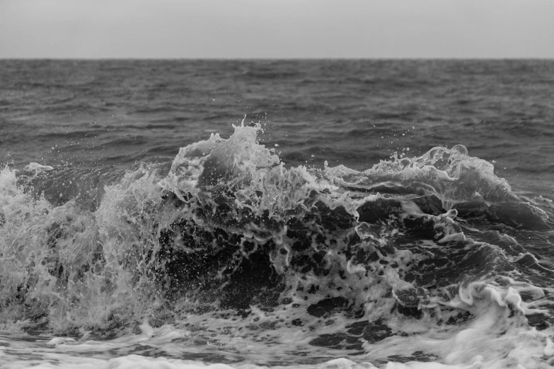 the person stands on a surfboard near the ocean