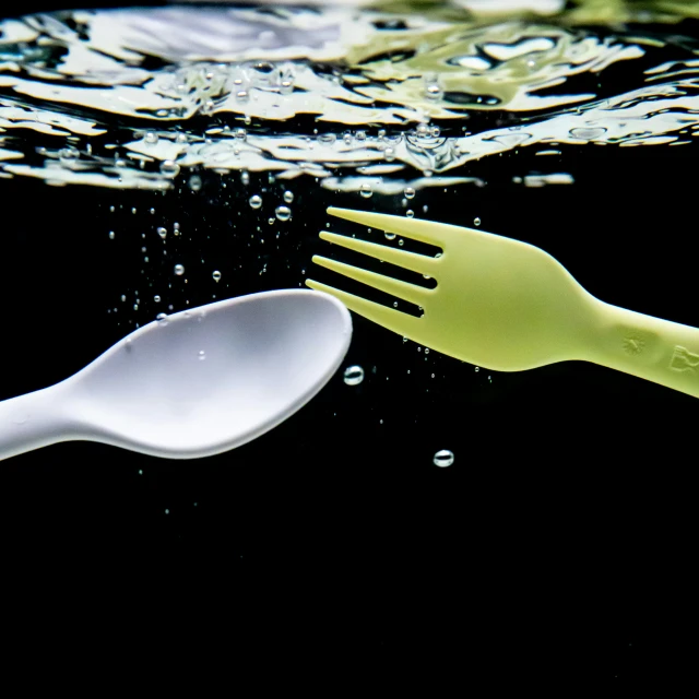 a spoon and fork with water spraying on them