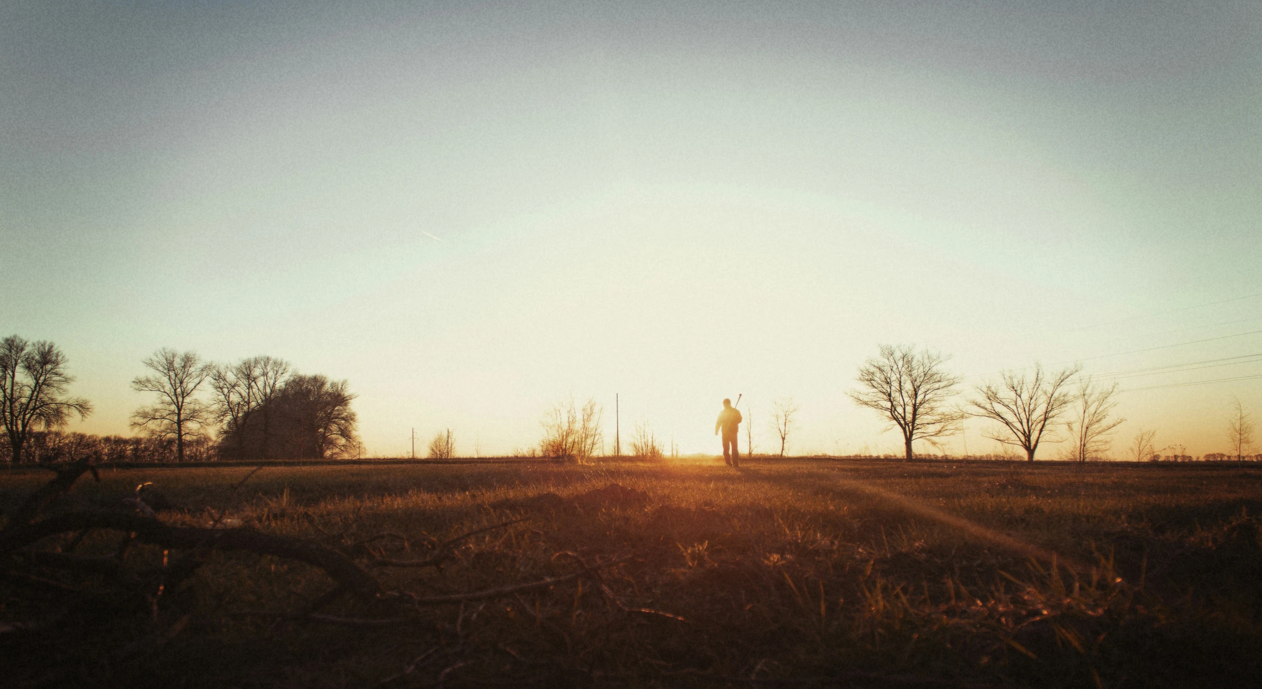 a man standing on top of a grass covered field