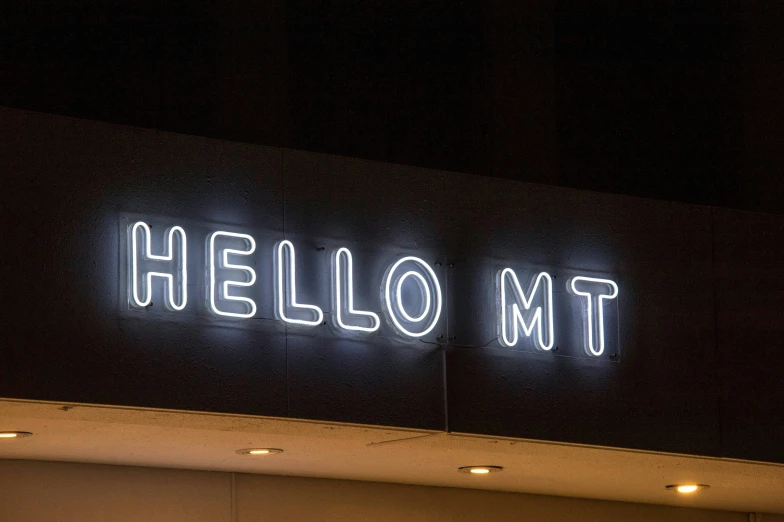 the back of a building with a lit neon sign