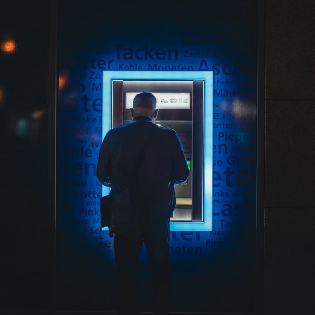 a man standing in front of an atm