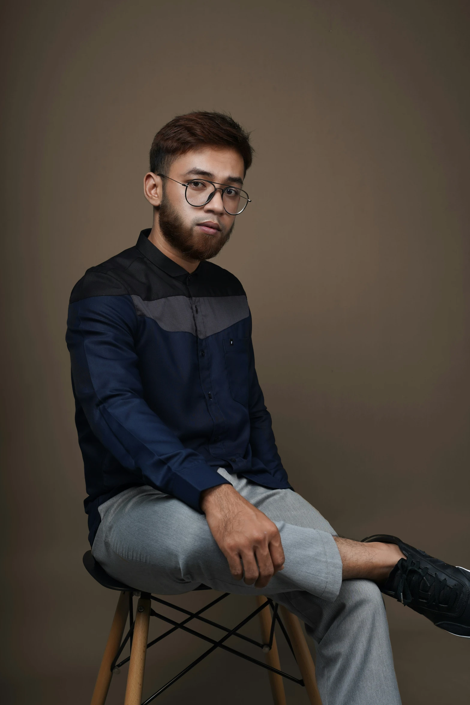 a young man sitting on top of a wooden chair