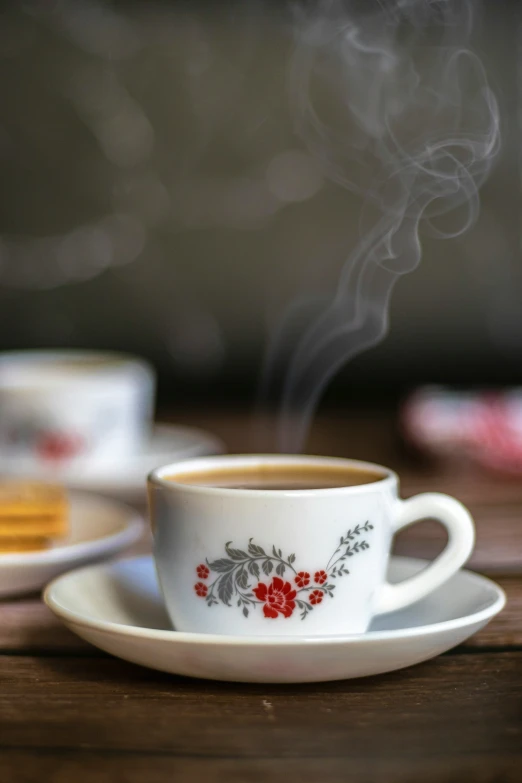 the steaming cup has red flowers on it