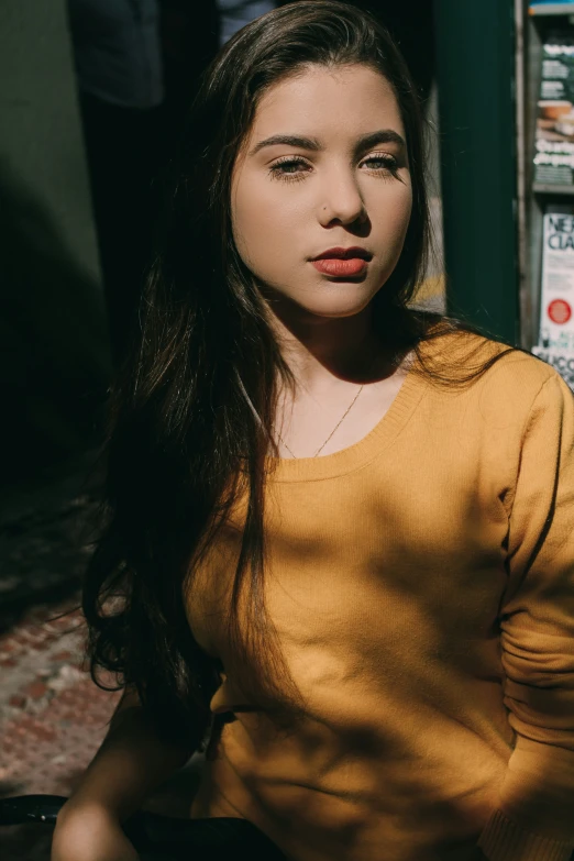 woman in yellow shirt posing at the camera