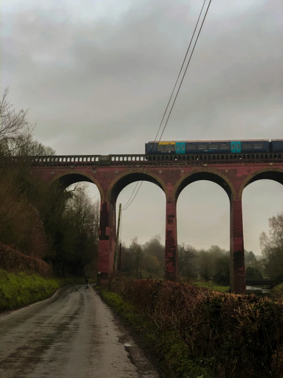 there is a train traveling over a large bridge