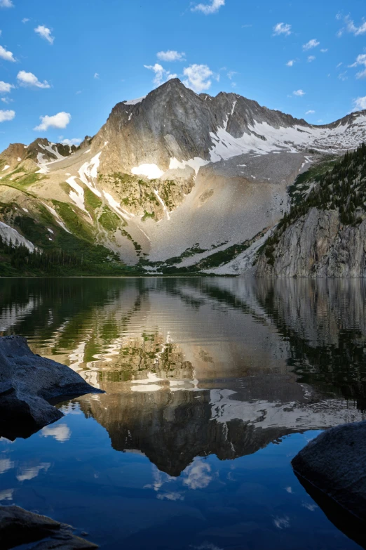 a mountain range reflecting in the lake