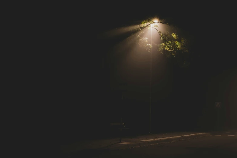 a dark street at night with one light on the side