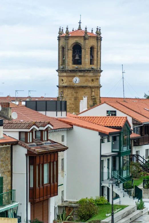 a tower clock is shown with houses around