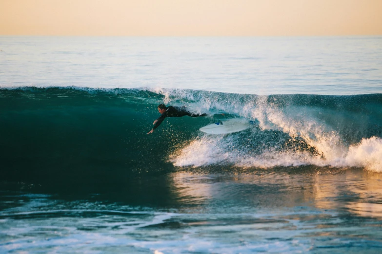 a person is riding a surfboard on a wave