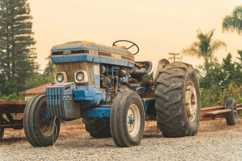 a large blue tractor sitting in the middle of a field