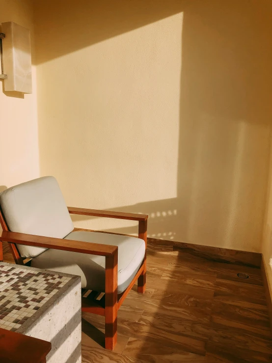 an empty chair and a mattress sit in front of a window