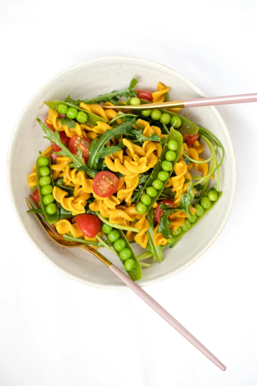 a white plate with green peas and pasta on top of it