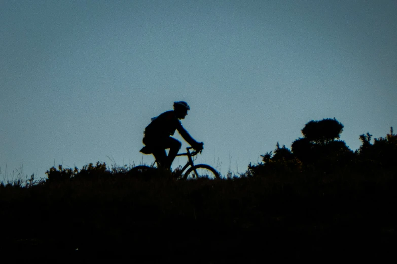 a man riding on the back of a bike down a hill