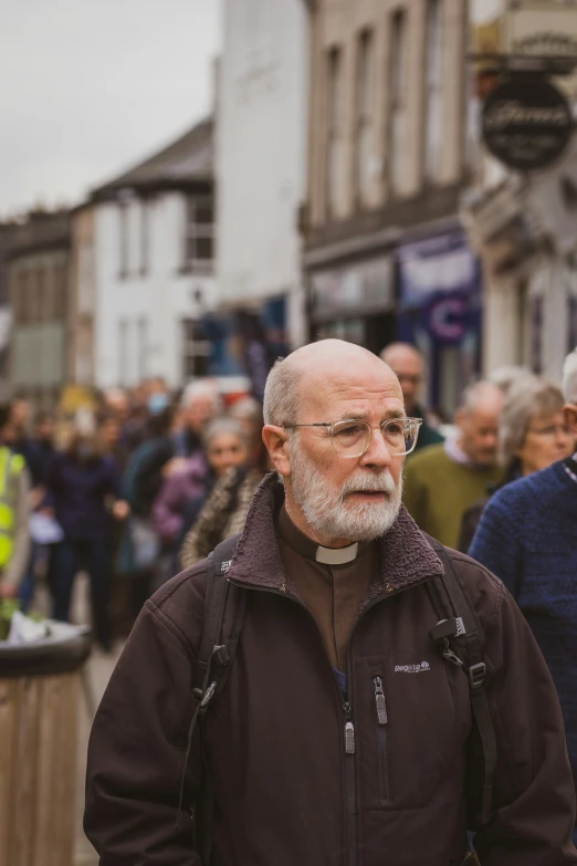 an old man in the middle of a crowd with people around him