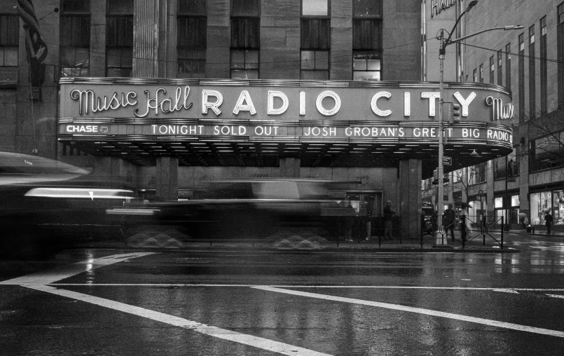 a theater sign in the rain next to the street