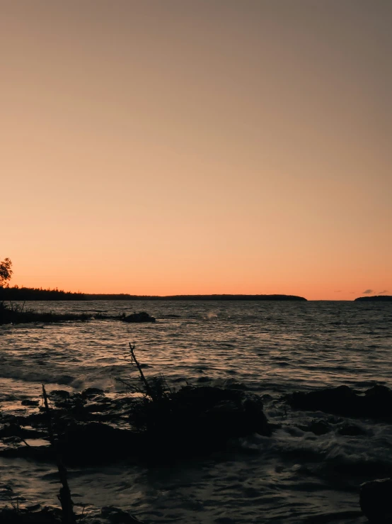 a person on some water at sunset with a boat