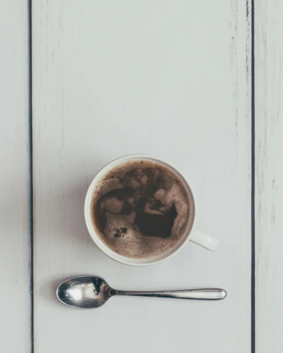 a cup filled with liquid and a spoon on a table