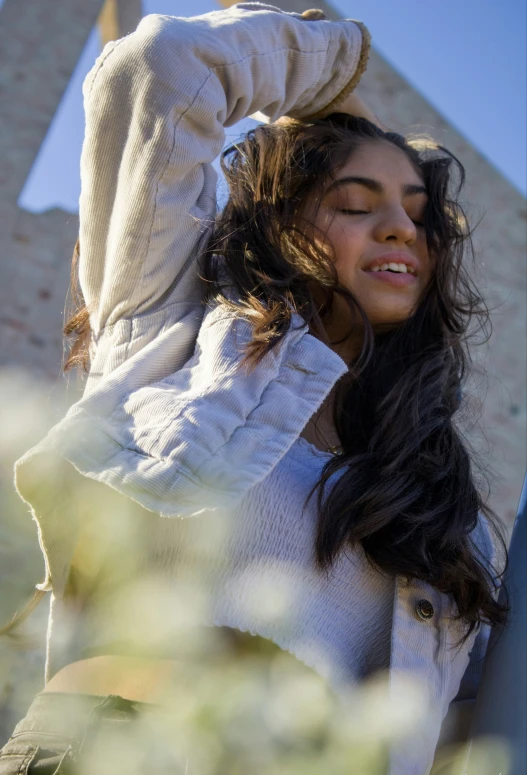 a woman stands smiling in a white jacket