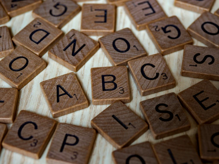 many letters are arranged and spelled on a wooden table