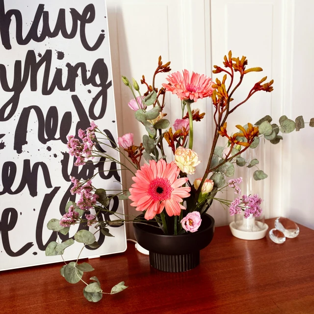 several beautiful flowers are on the table in the corner