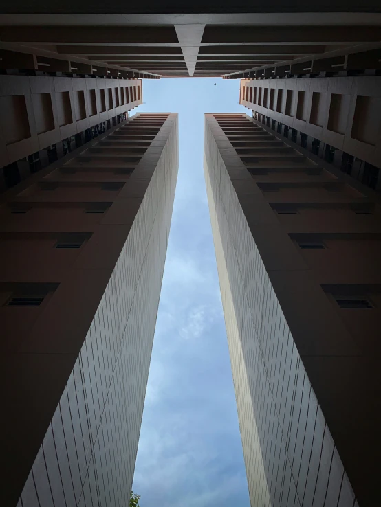 the sky between two buildings has a couple of people in it