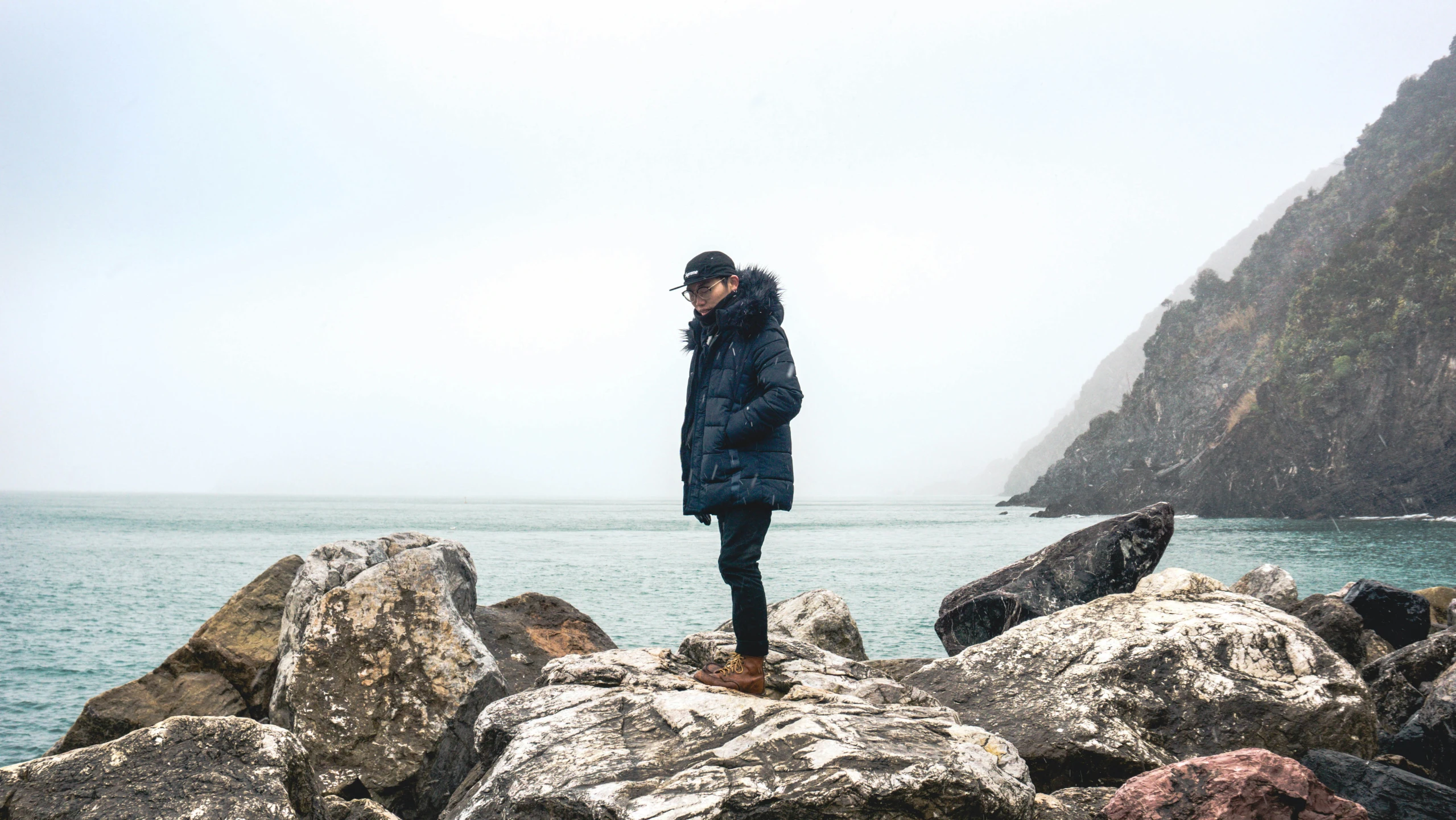 a man standing on top of a rock covered ocean