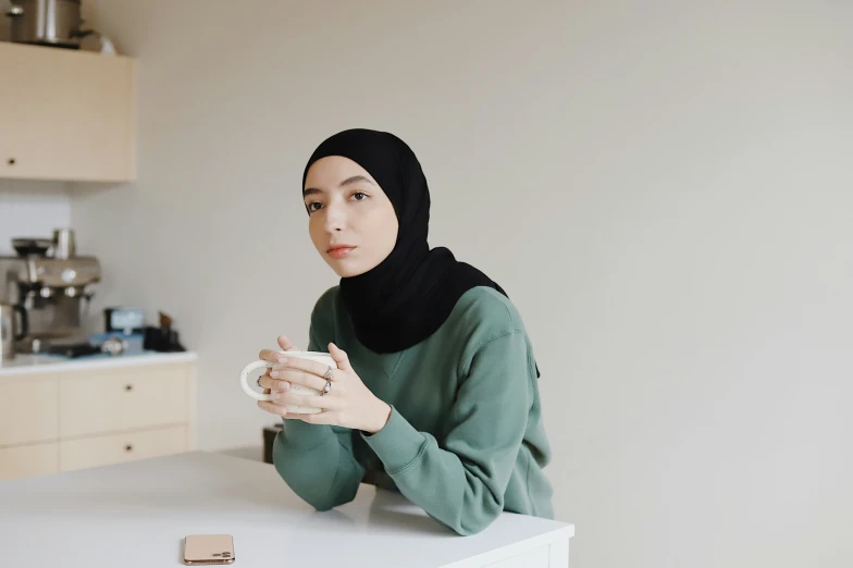 a woman wearing a headscarf is sitting at a table