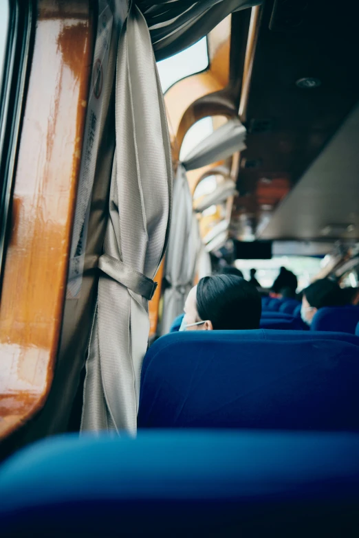 people are sitting in the passenger train compartment