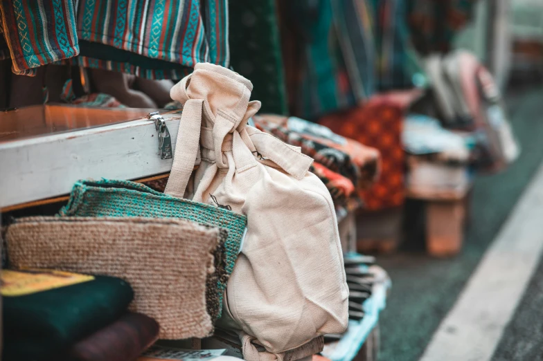 many different bags and clothes are piled on a display