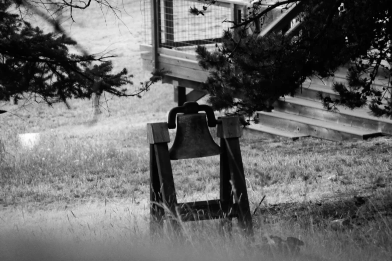 black and white pograph of a bell in the woods