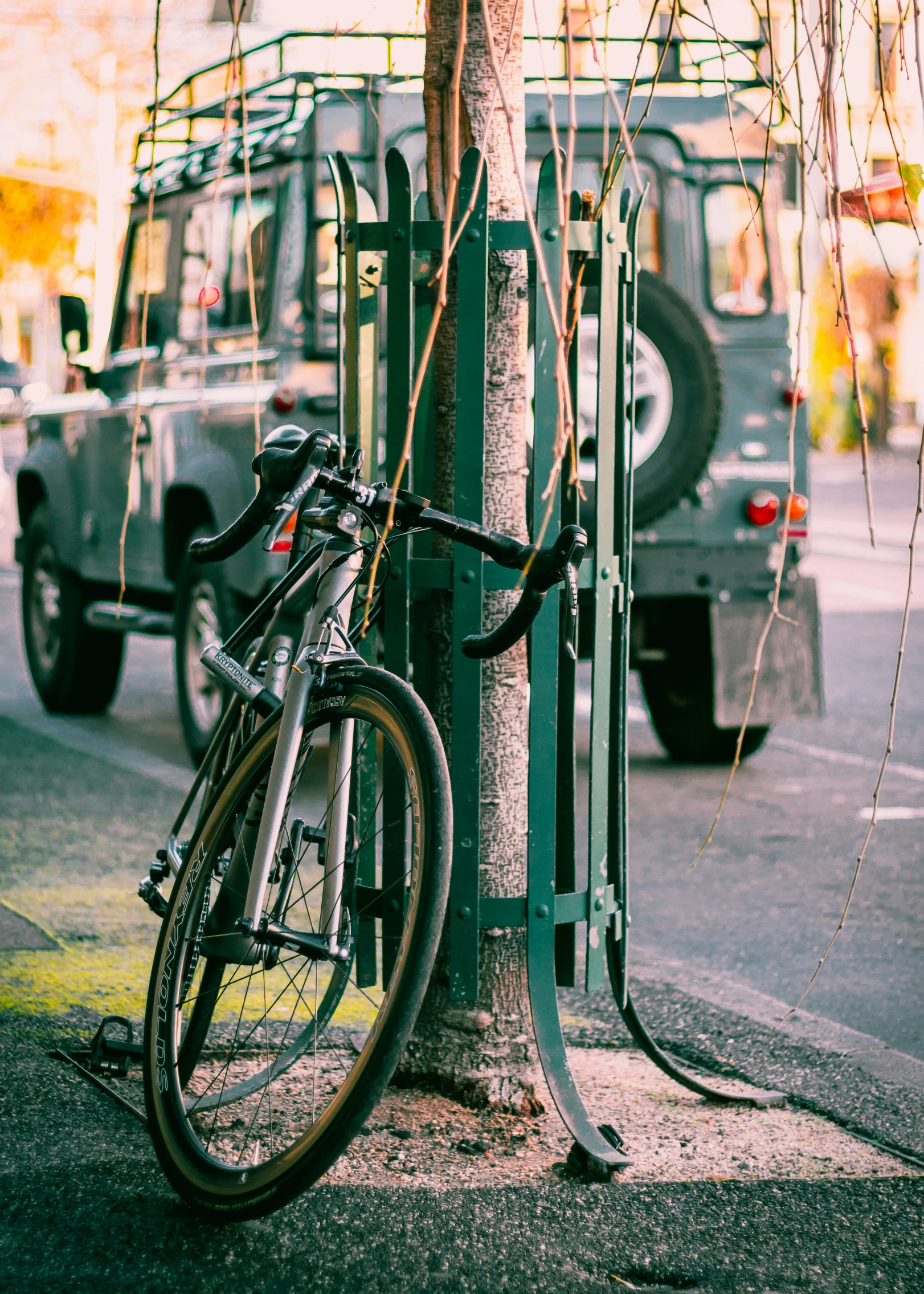 a bicycle tied to a pole with a parking meter