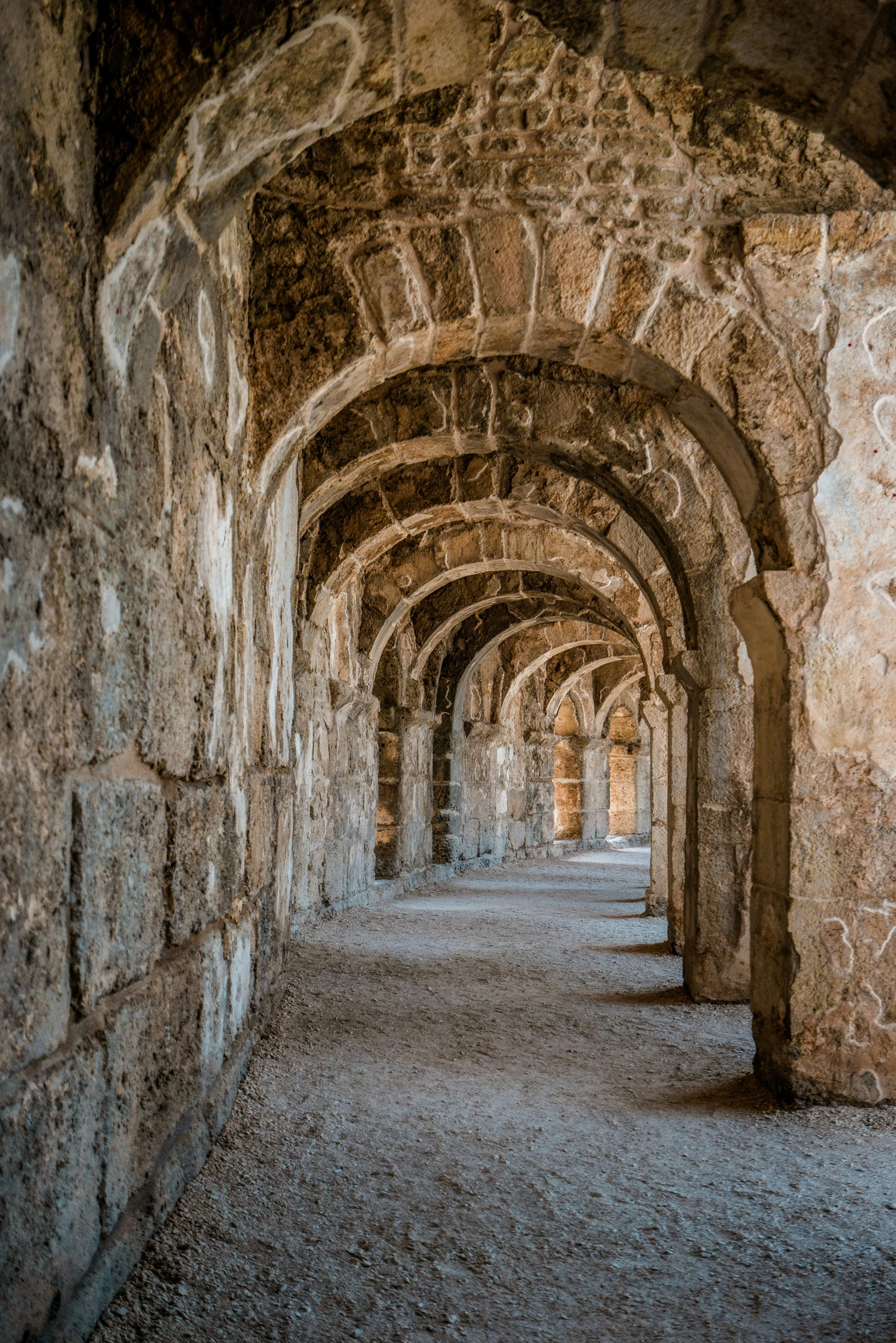 a building made out of rocks and stone pillars with arches