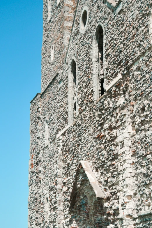 a large stone building with two windows and brick sides