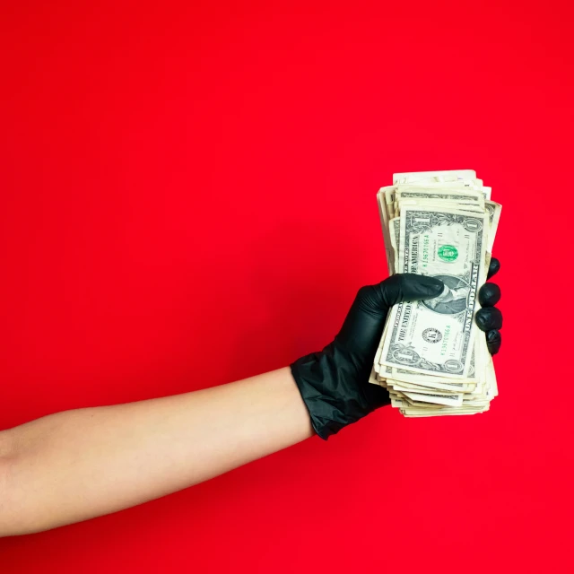 a hand holding one twenty dollar bills