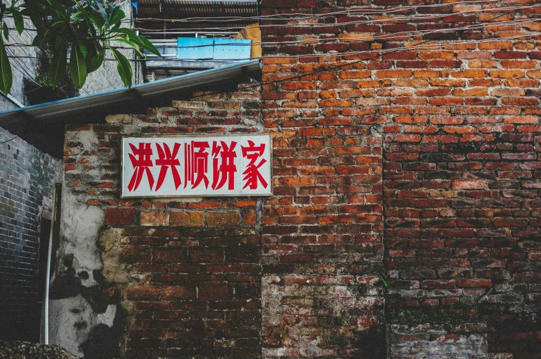 an asian sign is displayed on a brick wall