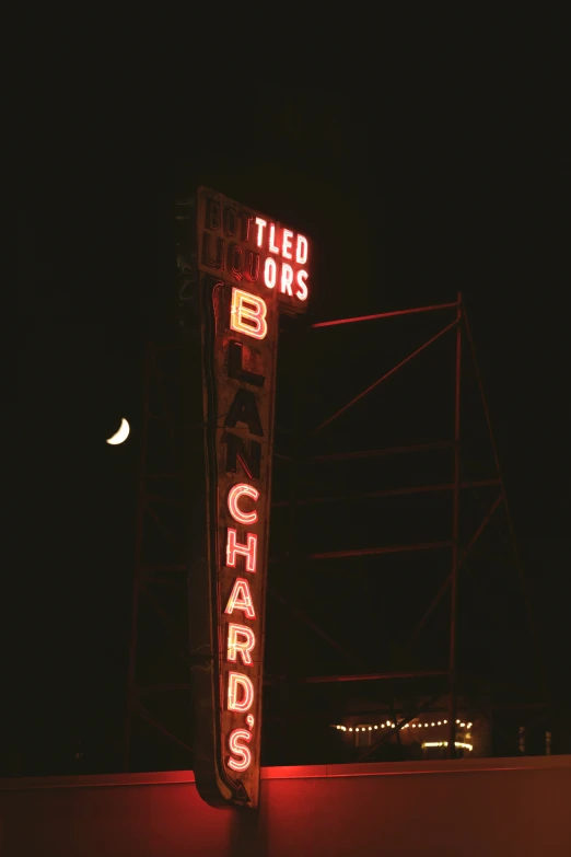 a neon sign in front of a building lit up