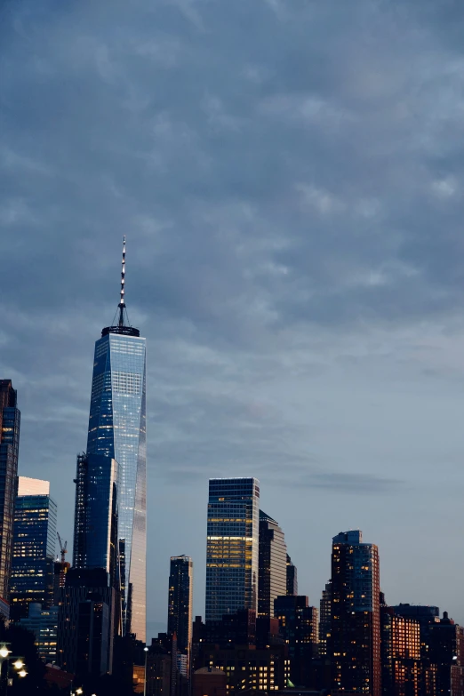 the new york city skyline seen at dusk from across the bay