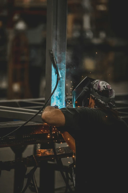 man working with welding equipment inside a steel factory
