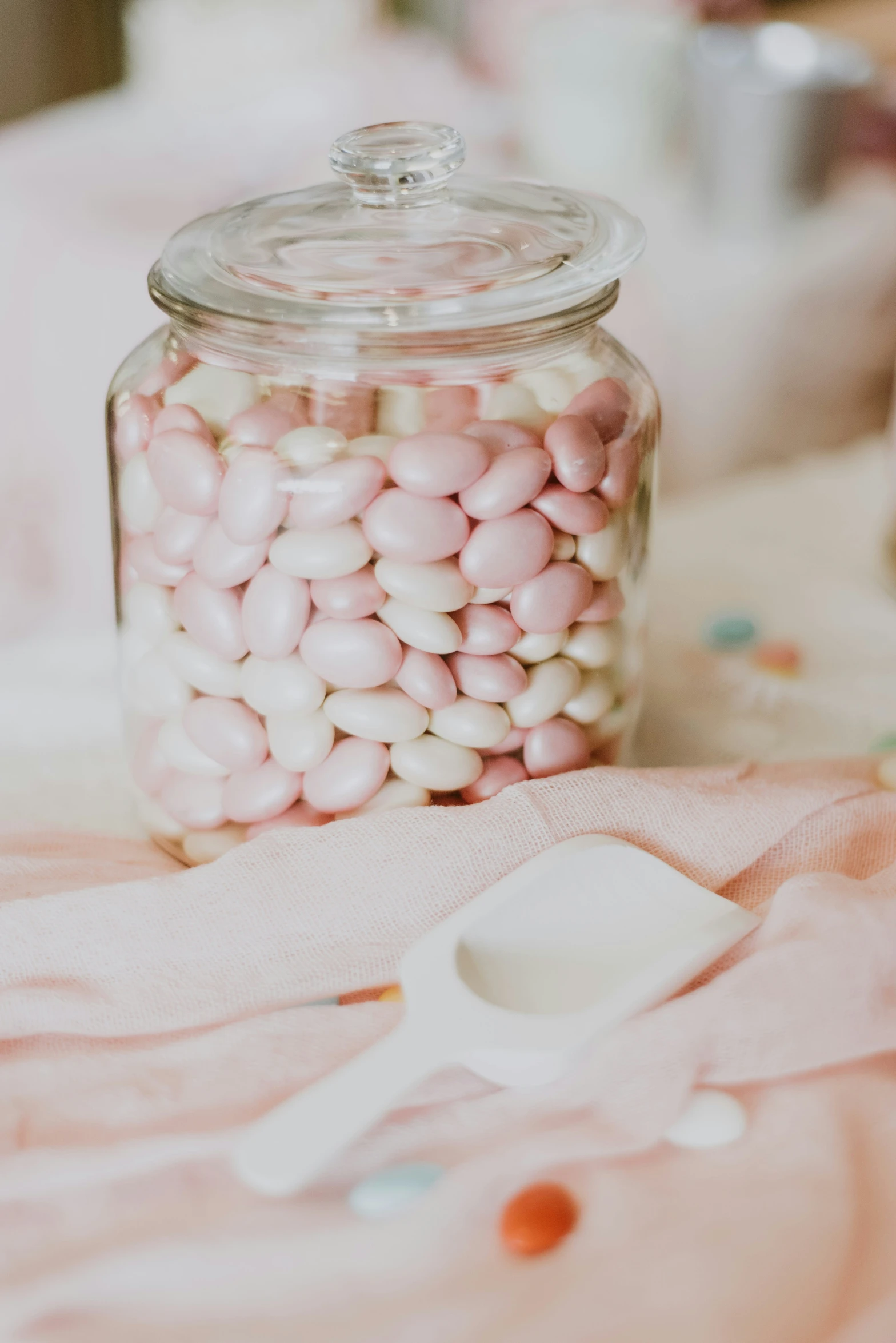 a small jar that has some pink and white candy in it