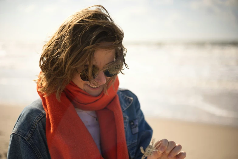 a lady standing on the beach with her hands folded