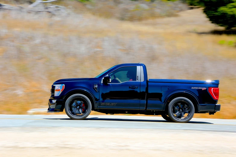 black pickup truck driving down a country road