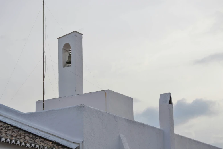 a church with a clock tower stands against a cloudy sky