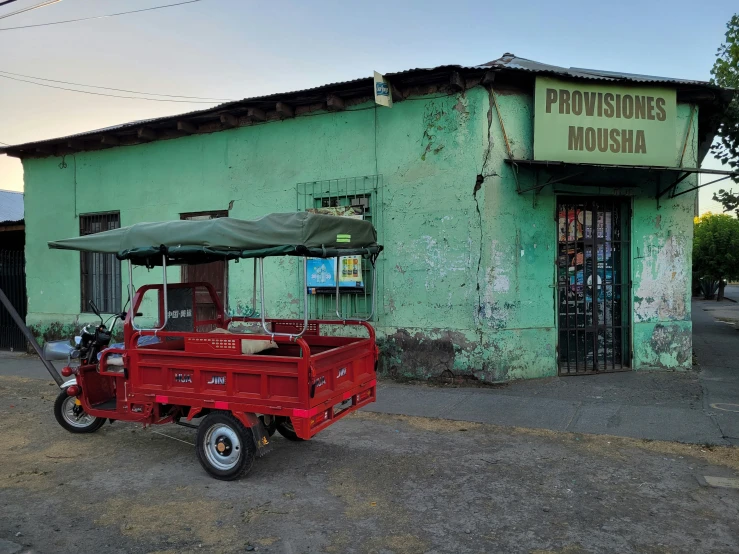 a red truck sits outside of a building with an awning