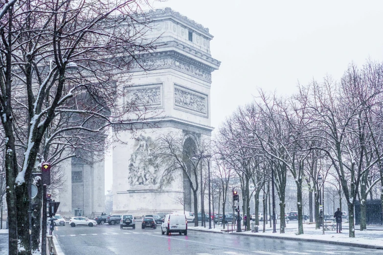 a snowy day with traffic and trees