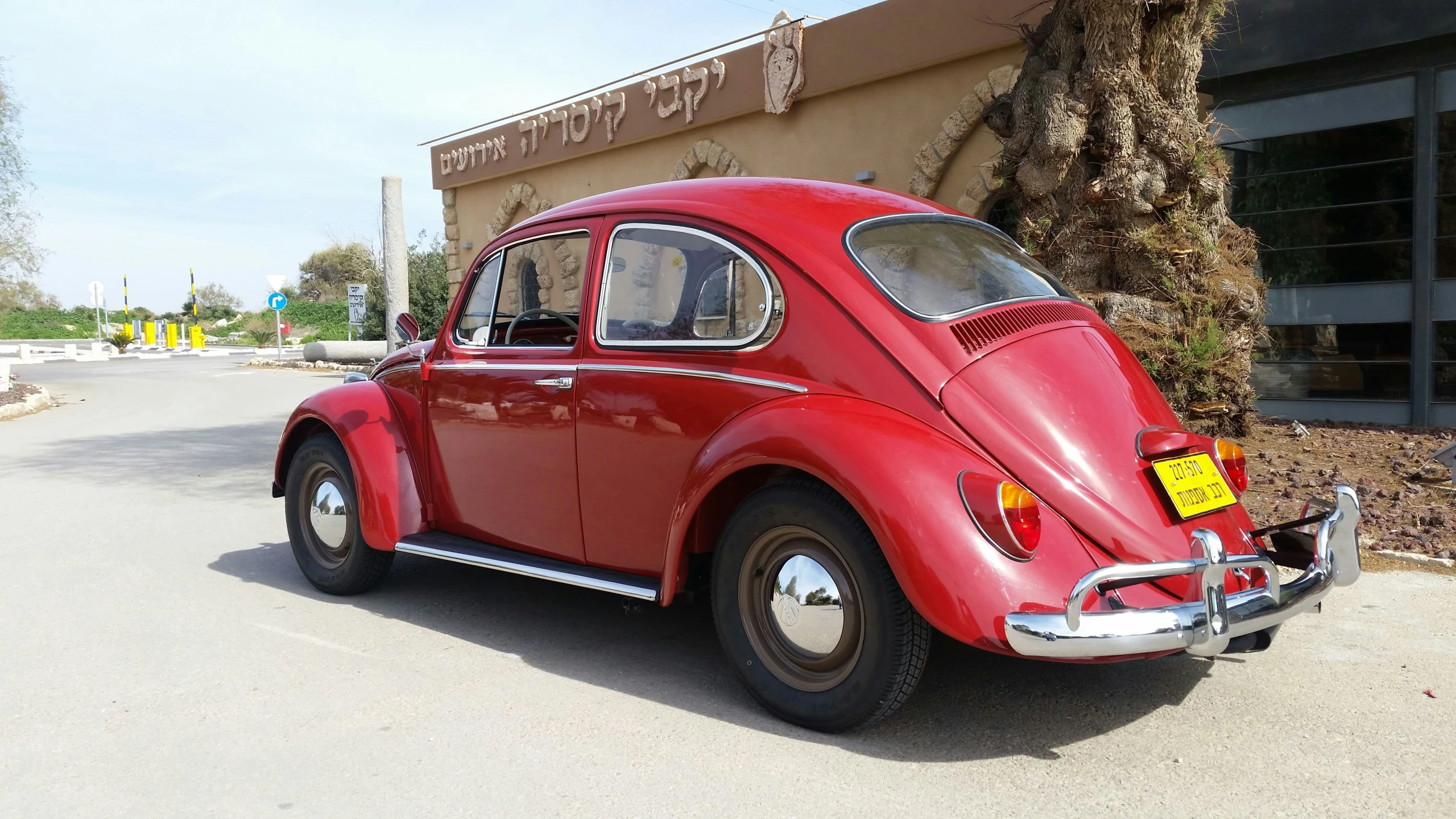 an old red beetle is sitting in front of a store