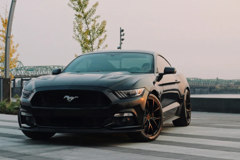 a black mustang muscle parked in a parking lot