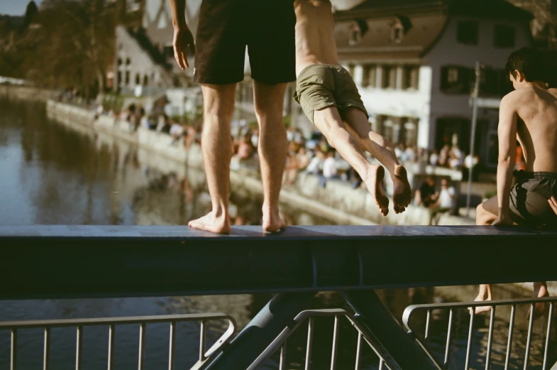 a couple of boys standing on a railing