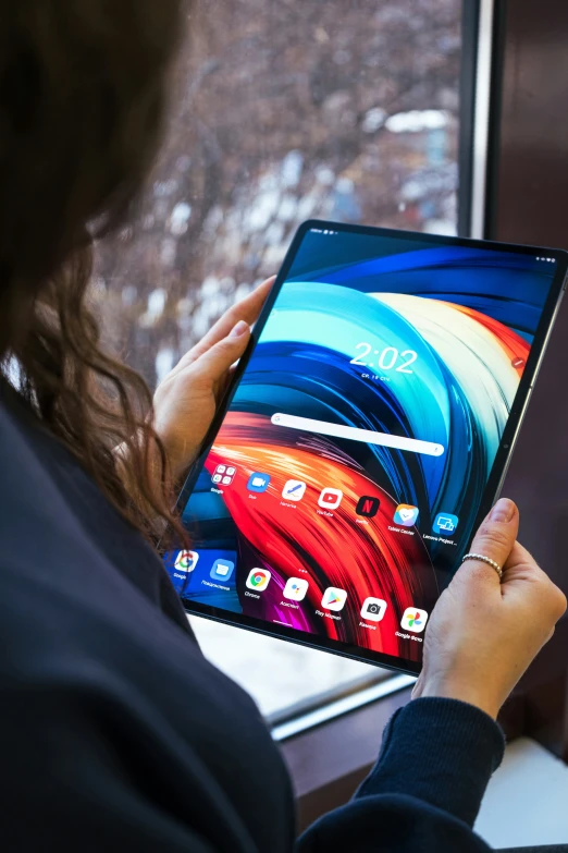 woman viewing the latest tablet with multi colored wallpaper