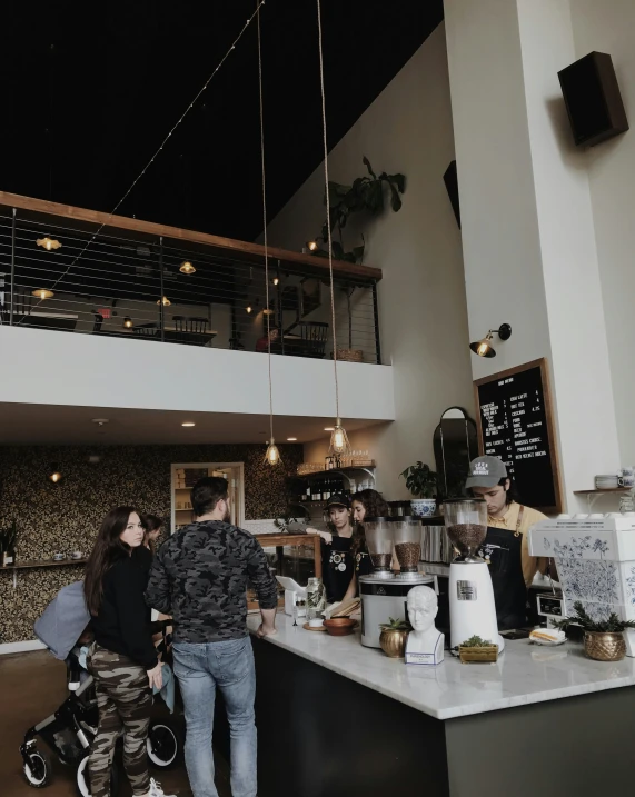 a restaurant with an espresso machine and multiple people